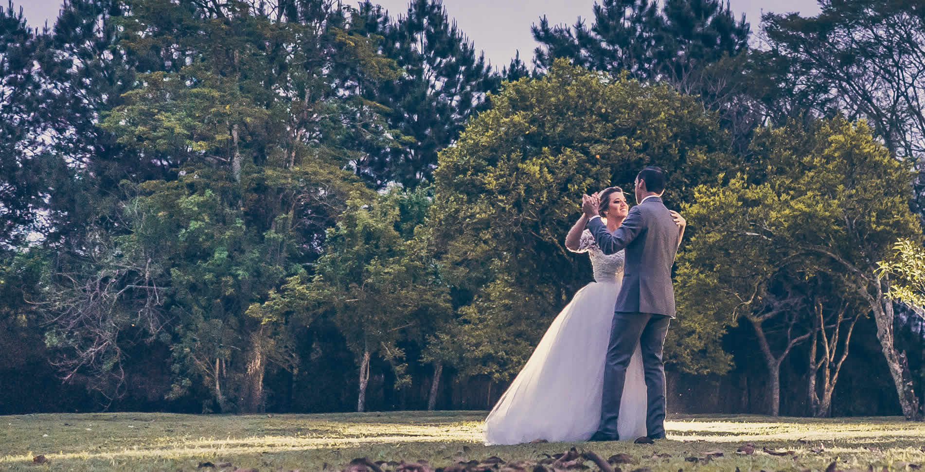 Casal de noivos dançando em ambiente natural